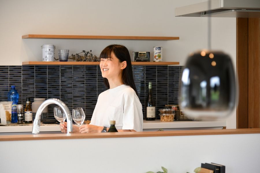 キッチンに立って窓の方を眺める女性