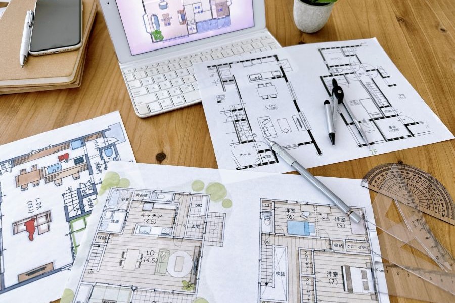 机の上に広げられたノートPCと間取り図